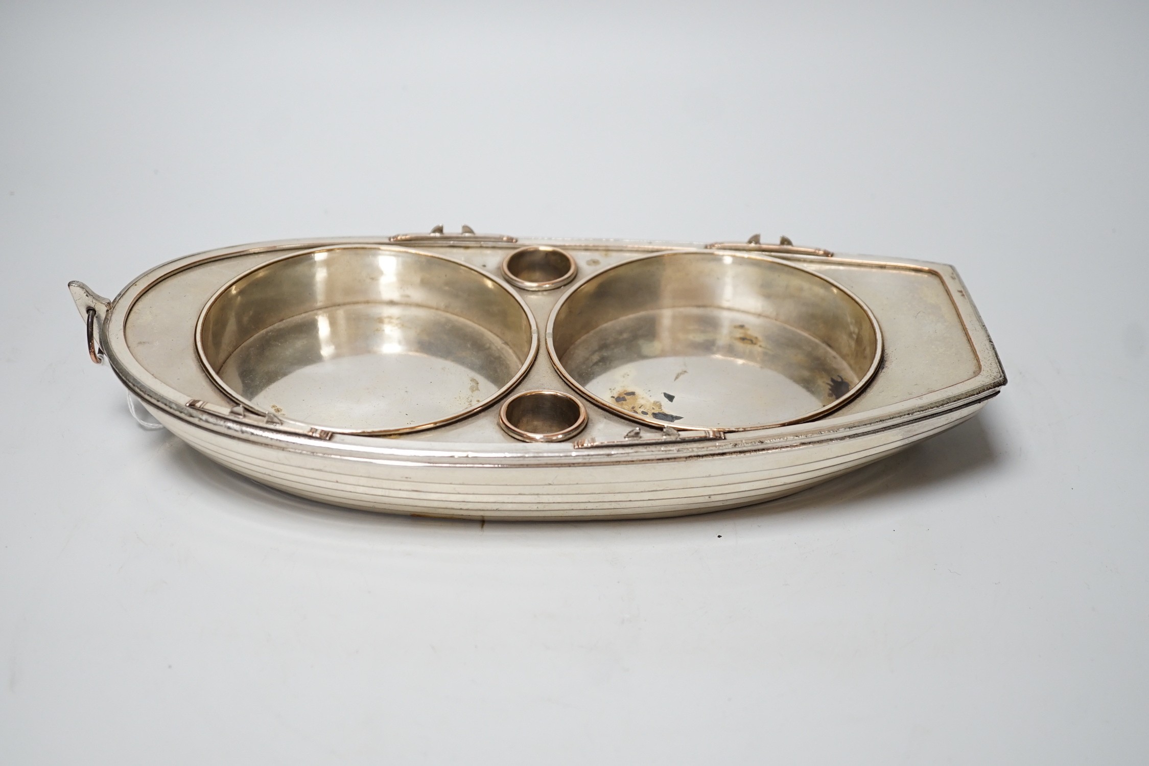 A late Victorian silver plated bottle coaster modelled as a rowing boat, 32cm long